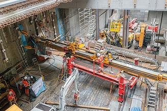 Drilling machine in operation on a construction site with several workers performing drilling operations