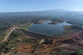 Aerial view of a reservoir with an earthfill dam, access roads and associated infrastructure surrounded by a rural landscape in Kenya.