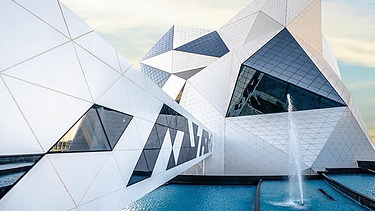 Futuristisches Gebäude der Sky-Venture-Anlage auf Yas Island mit weißer Fassade und großen Glasflächen