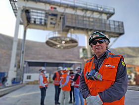 Bergbaustandort der Untertageerschließung Chuquicamata mit Förderanlage, Baustellenpersonal in Schutzkleidung und Mineninfrastruktur im Hintergrund